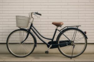 白い壁の住宅に寄り添う紺のママチャリ