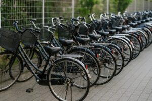 フェンス沿いに並ぶ青いママチャリの列