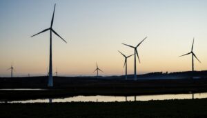夕暮れ時の風力発電所と静かな水辺