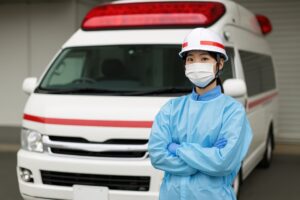 屋外で救急車と共に立つ救命スタッフ