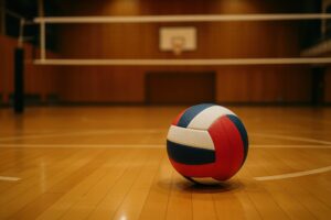 夕方の体育館に置かれた赤青白バレーボール