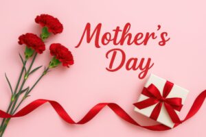 リボンとギフトとカーネーションが並ぶ母の日のイメージ