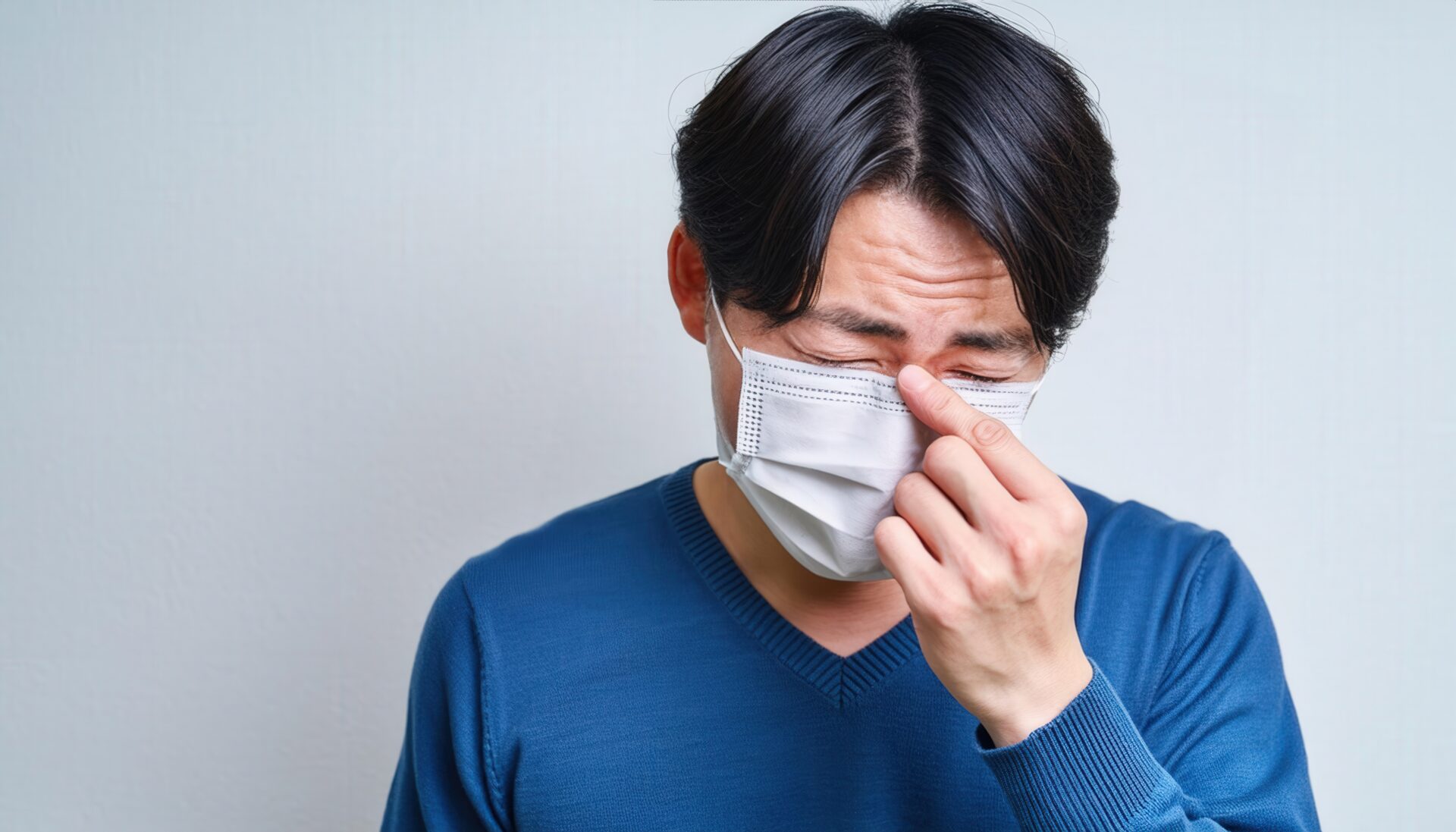 花粉症に苦しむマスクを着用した男性