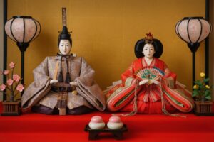 金屏風の前に飾られた雛人形と桃の節句の飾り
