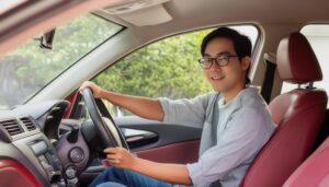 赤い車に乗る眼鏡をかけた男性