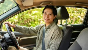 車を運転中の男性（車内・左手をハンドルにかける）