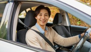 車を運転中の男性（白い車・微笑む表情）