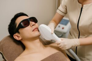 ゴーグル着用で顔脱毛を受ける男性と施術者の手元