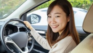 車を運転中の女性（自然背景と白い車）
