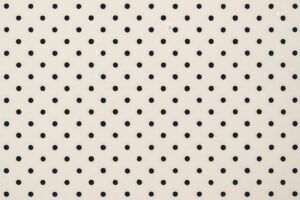 黒いドットが並ぶシンプルなベージュ背景