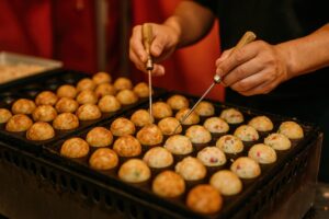 屋台で両手を使ってたこ焼きを返す様子