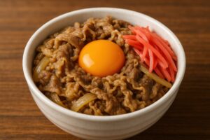 紅生姜と卵黄がトッピングされたシンプルな牛丼