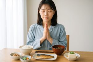 落ち着いた表情で朝食前に手を合わせる女性