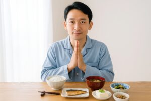 朝食前に手を合わせて感謝を示す男性