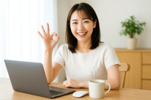 パソコン作業中にOKサインを出す女性