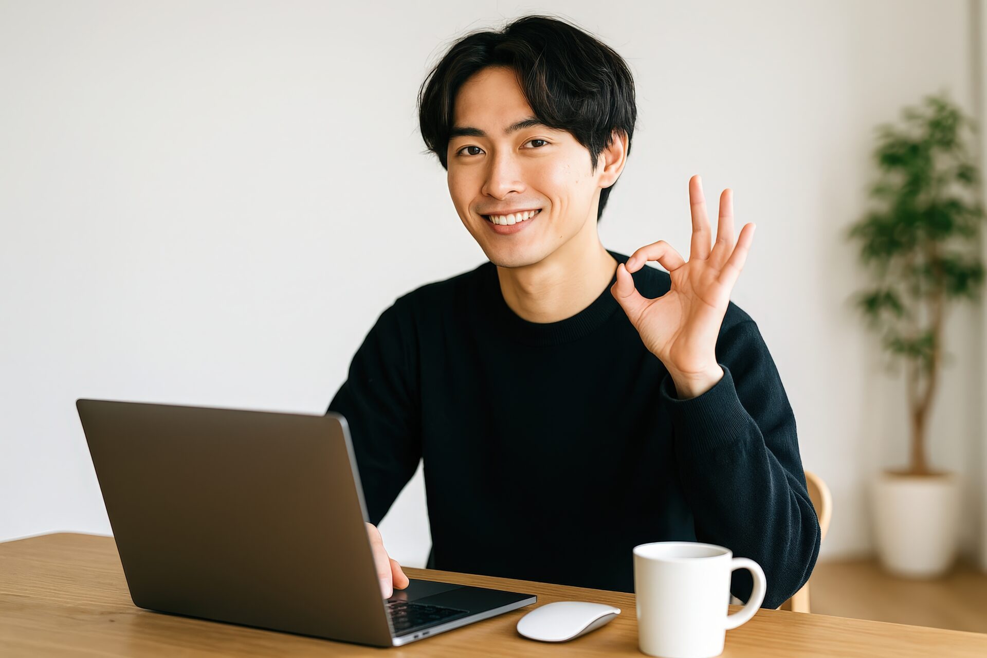 OKジェスチャーをする黒い服の若い男性