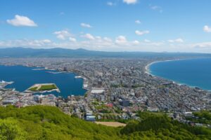 青空の下に広がる函館市街と海岸線の風景