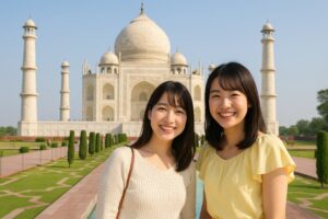 快晴のタージマハル前で観光を楽しむ若い女性二人