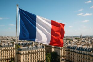 青空とパリの屋根を背景に揺れるフランス国旗
