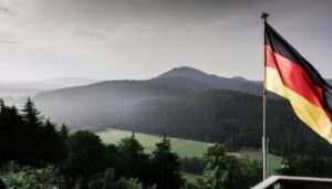 朝靄の中の山とドイツの国旗