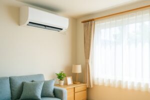 明るいリビングに設置された白い壁掛けエアコン