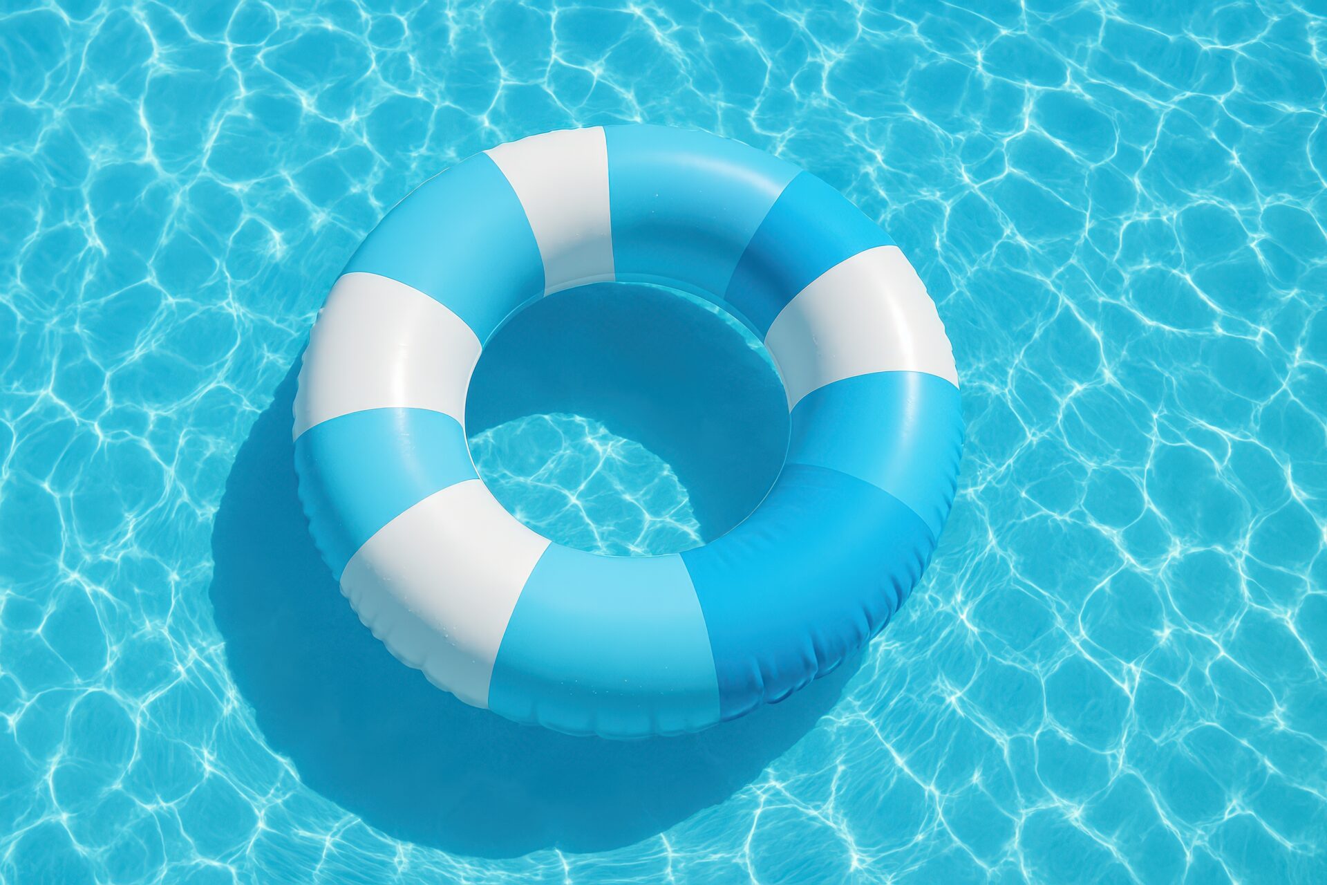 青と白の浮き輪が浮かぶプール