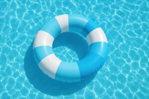 青と白の浮き輪が浮かぶプール