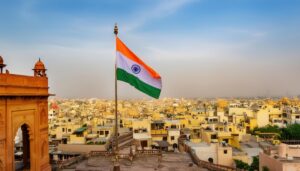 風になびくインド国旗とインドの都市