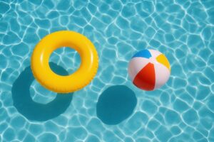 黄色い浮き輪とビーチボールのあるプール