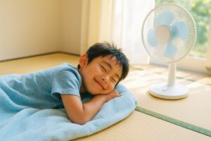 扇風機の前で微笑みながら昼寝する男の子