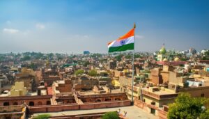 風になびくインド国旗とインドの都市