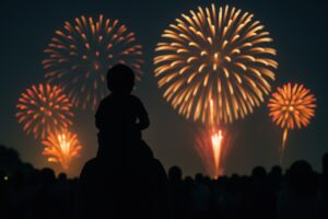 大輪の花火を肩車で楽しむ親子のシルエット