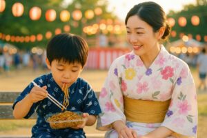 ベンチで焼きそばを食べる男の子と見守る母親