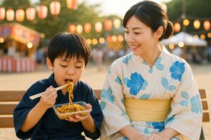 夏祭りで母子が焼きそばを食べて楽しむ様子