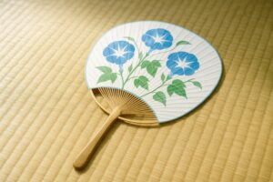 畳の上に置かれた青い朝顔のうちわ