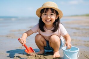 砂浜で楽しそうに砂遊びをする女の子
