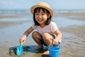 海辺で笑顔でスコップを使う女の子