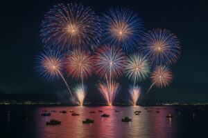 湖上で打ち上がる大輪の花火と船の灯り