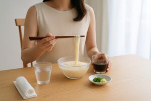 そうめんをつゆにつけて食べる若い女性