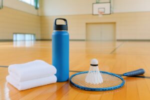バドミントンラケットとシャトルとボトルとタオル