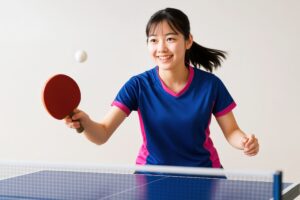 卓球ラリー中に笑顔を見せる女子学生