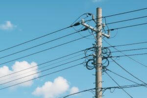 青空に映える交差する電線と電柱