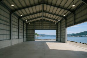 海が見える倉庫の内部とシャッター越しの風景