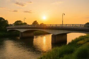 夕暮れの太陽と川面を照らす橋のシルエット