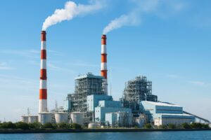 工場の煙突から白煙が上がる発電所の外観