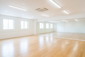 白を基調とした床と鏡のある多目的スタジオ