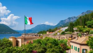 湖と山を背景に立つイタリアの国旗