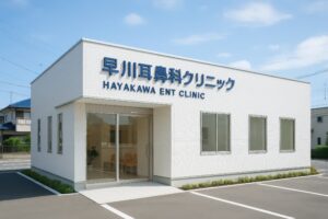 白い壁に青いロゴが映える早川耳鼻科クリニックの建物外観