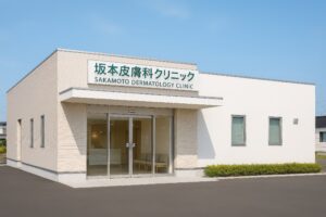 坂本皮膚科クリニックの緑のロゴが目立つベージュの建物