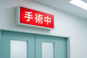 「手術中」の表示が点灯した病院の扉